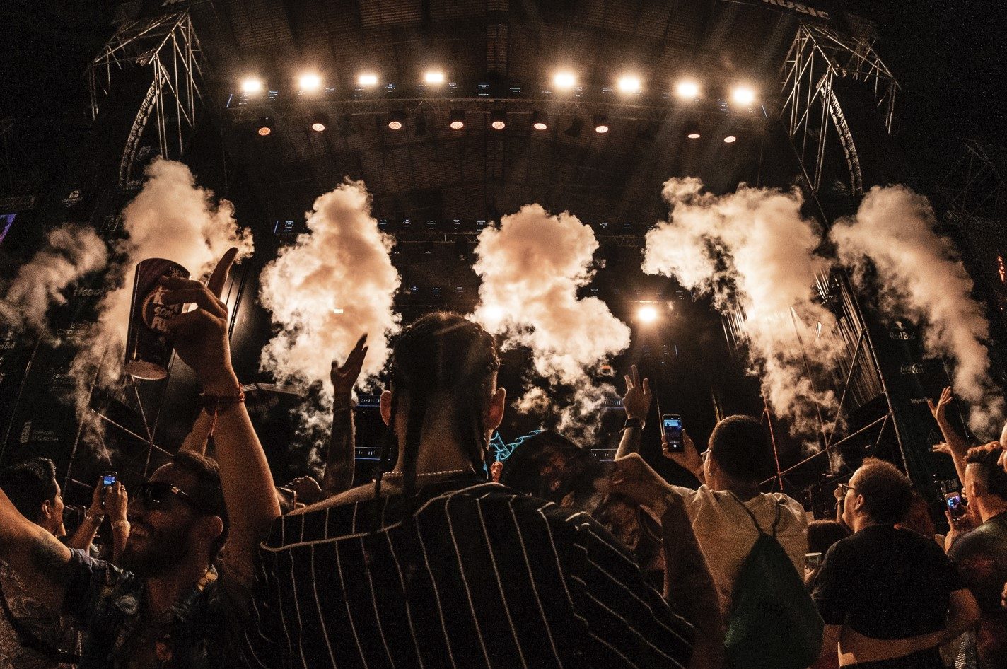 Público y columnas de humo frío en un concierto de noche